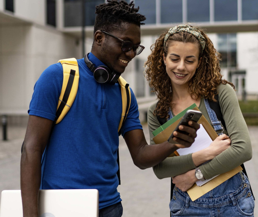 College kids, one male and one female - both looking at smartphone and talking