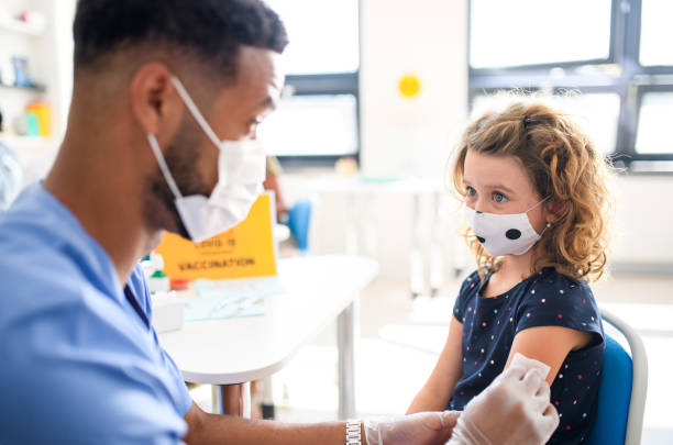 Doctor giving vaccination to girl