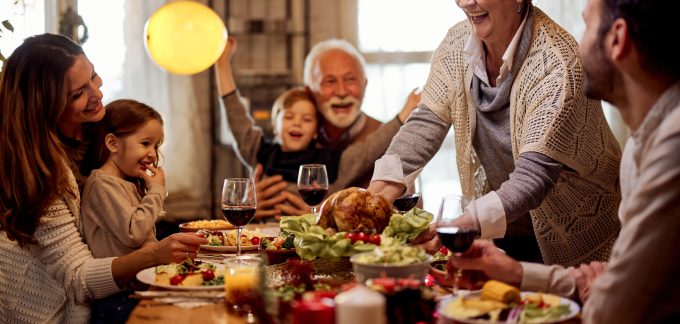 A family gathers around the table for Thanksgiving dinner.