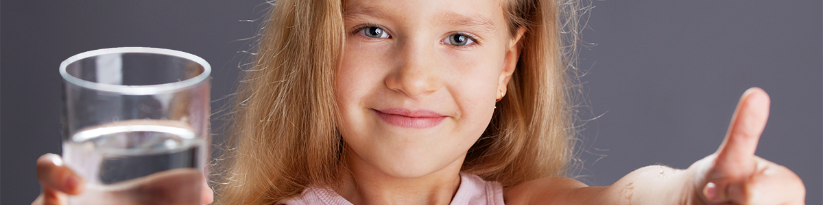 Girl with glass of water and thumbs up